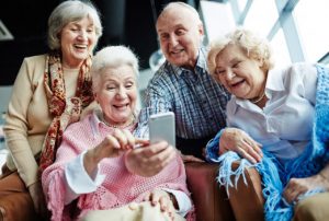four-happy-seniors-looking-at-smartphone